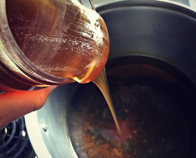 pouring the honey into a pot