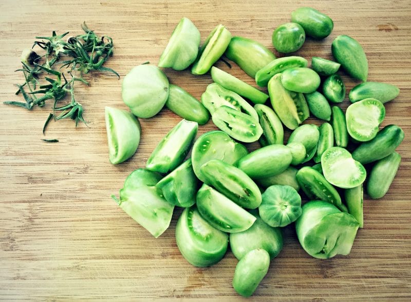 cut green tomatoes on a cutting board