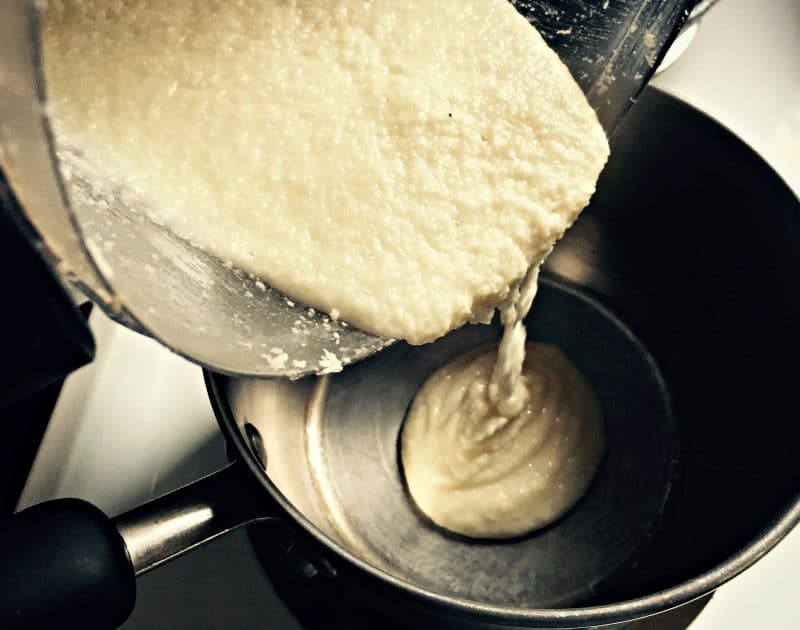 pouring coconut butter into a pot