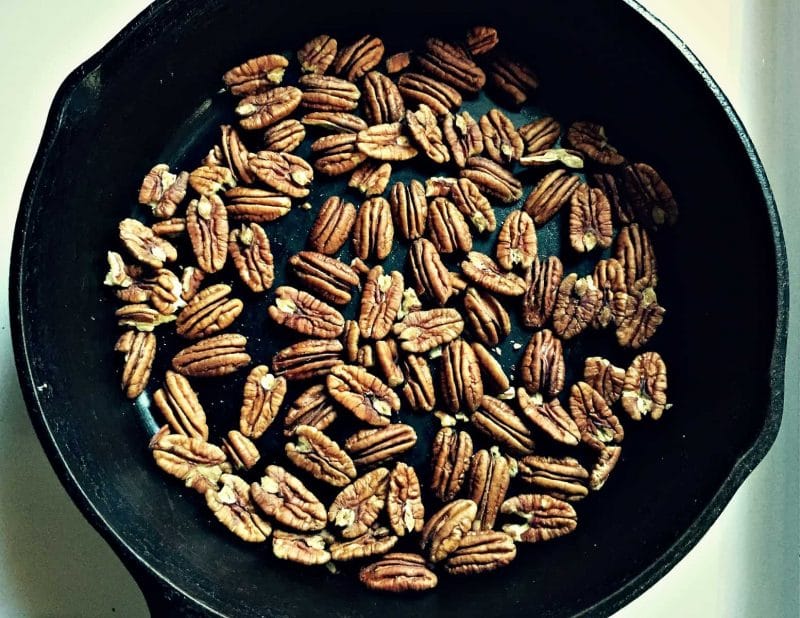 pecans roasting in a cast iron skillet