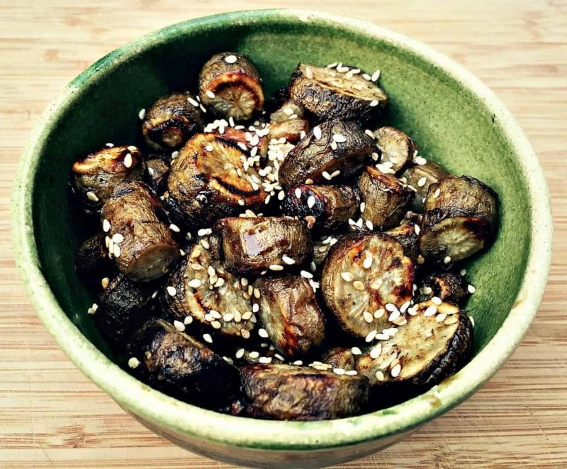 roasted burdock root with sesame seeds in a green bowl