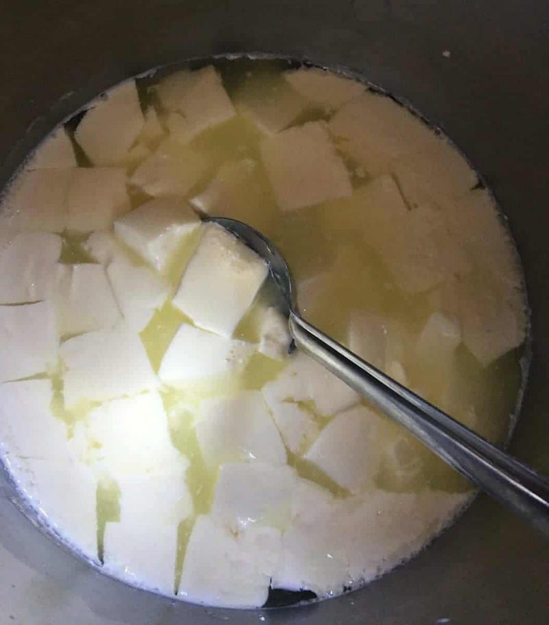 a spoon stirring the cheese curds