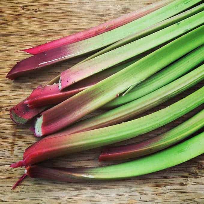 stalks of fresh rhubarb on a wooden board