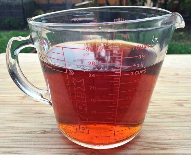 strained conifer infused vodka in a glass measuring cup