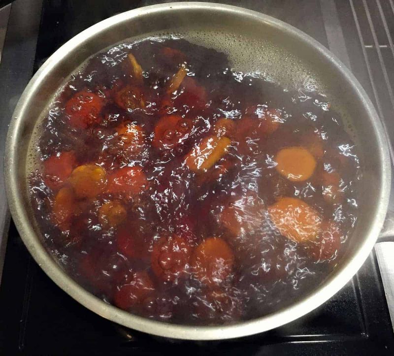 turmeric root pieces boiling in a pot of water