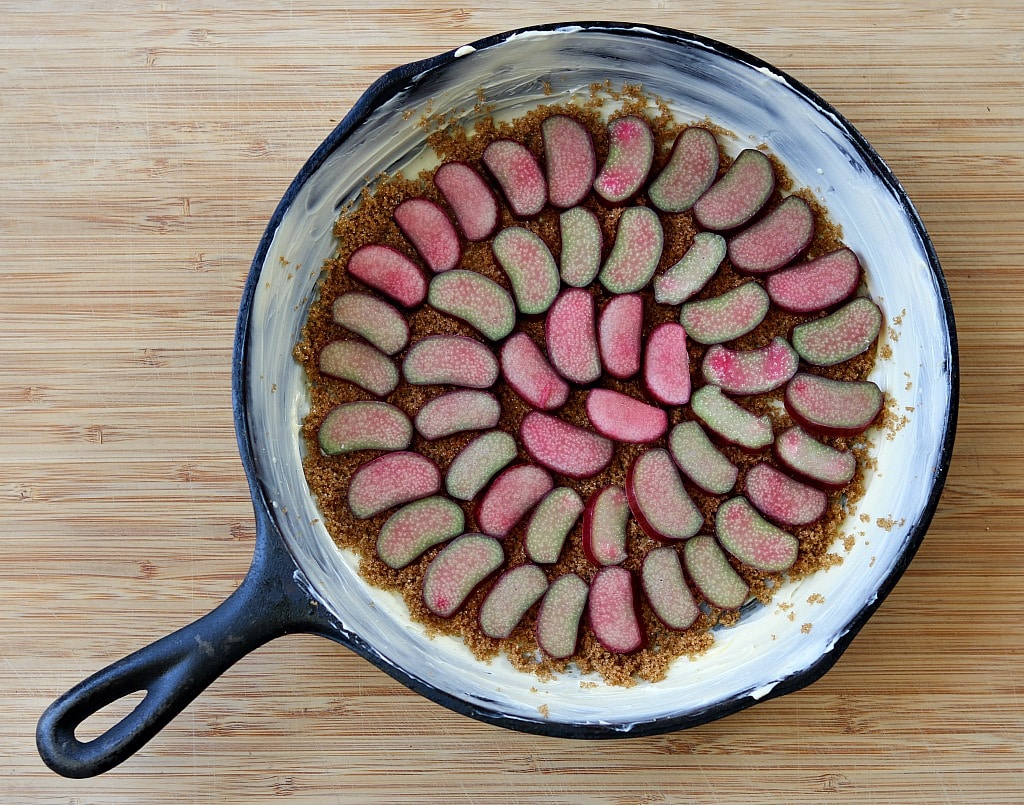 rhubarb slices in the bottom of a buttered cast iron skillet