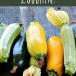 A variety of fresh zucchini on a wood table, ready to be preserved.