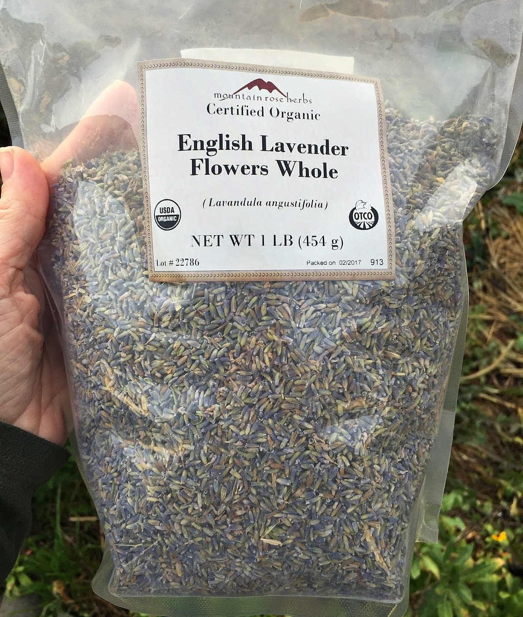 a hand holding a bag of Mountain Rose Herbs dried lavender flowers