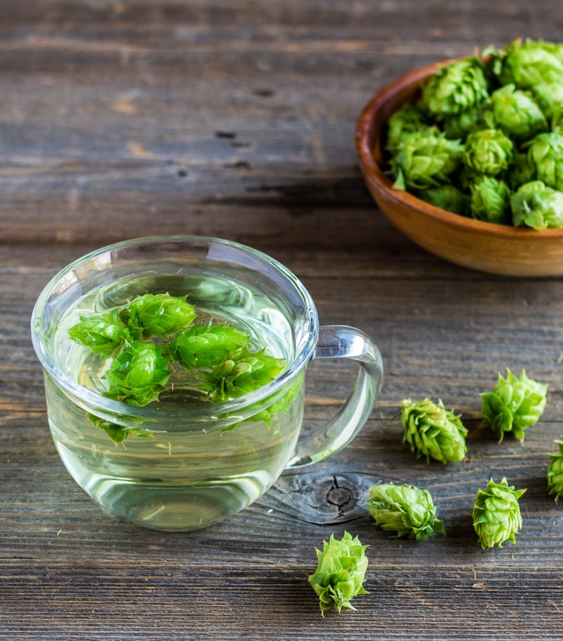 a mug of hop tea on a wooden board