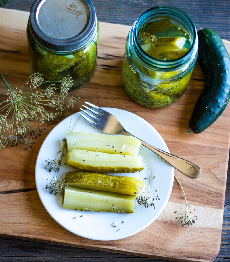 dill pickles on a plate with a fork