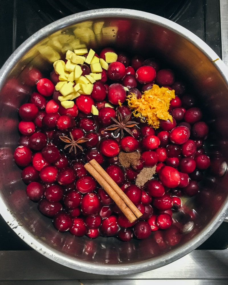 cranberries in a pot with ginger and spices