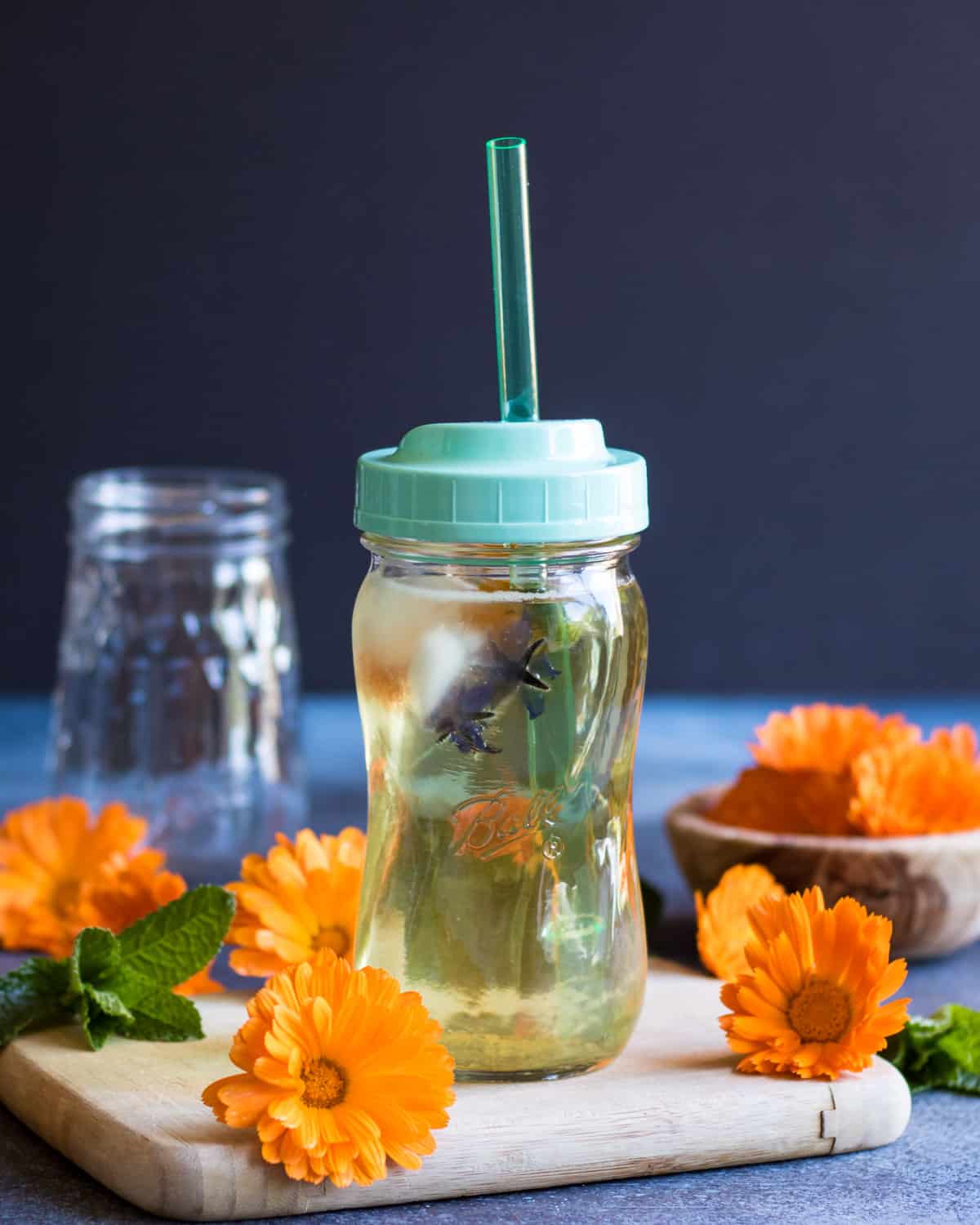 calendula iced tea served in a ball sip and straw jar