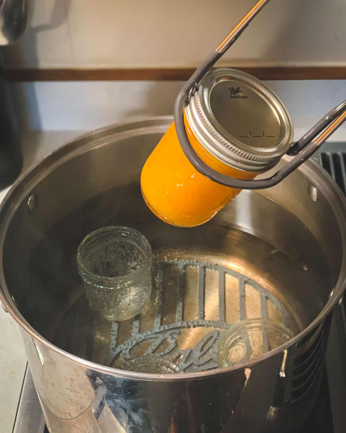 putting the peach jam into the water bath canner