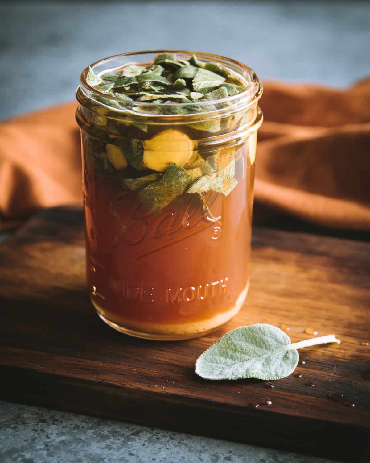 a ball pint jar with sage and ginger oxymel