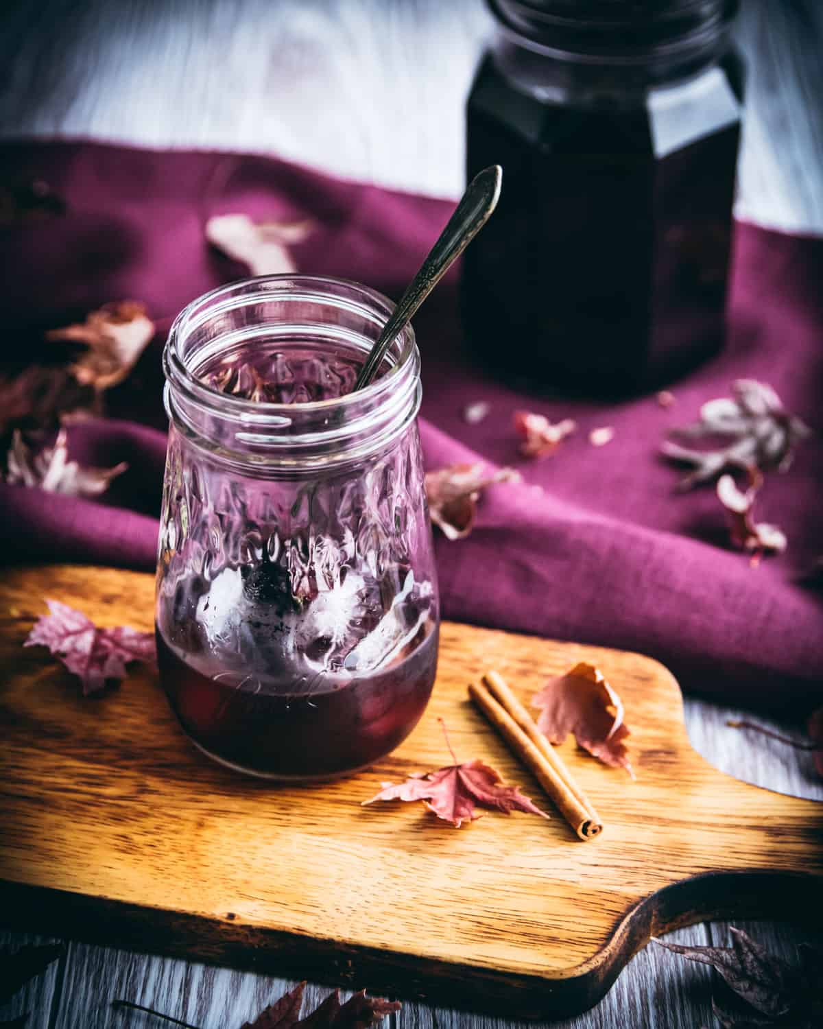 elderberry syrup in a jar with ice and a spoon