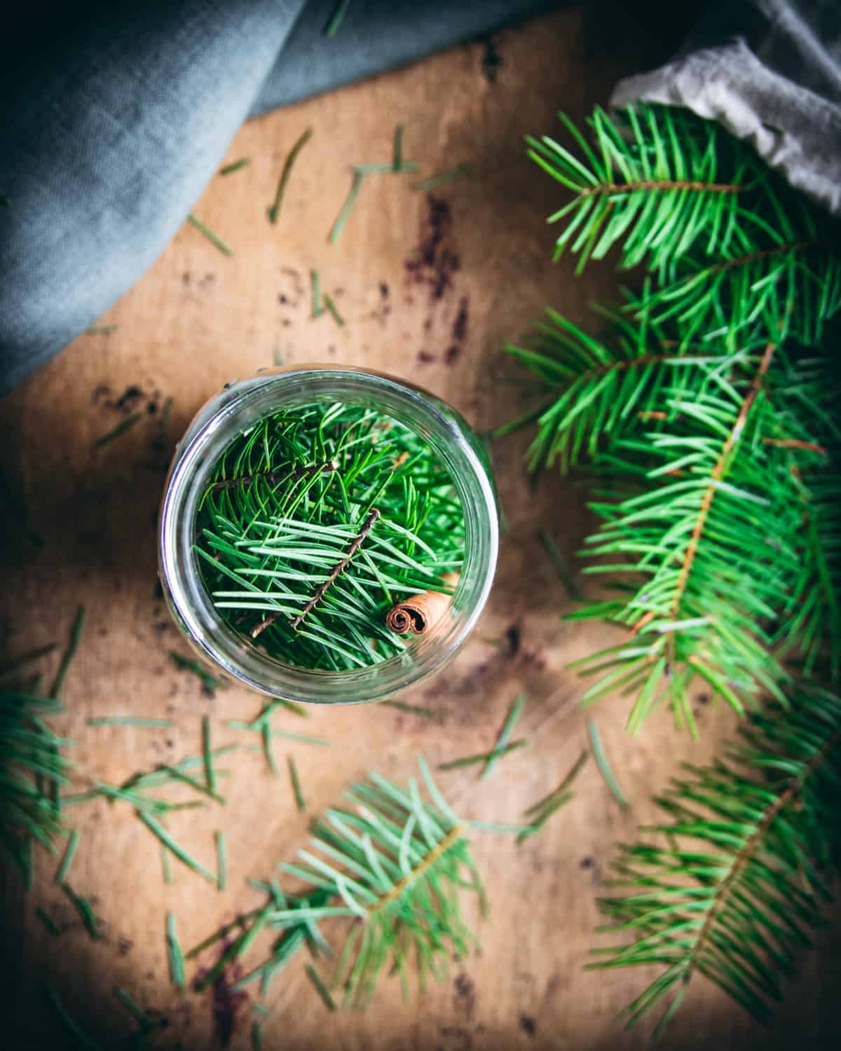 top view of a jar full of conifer needles and a cinnamon stick