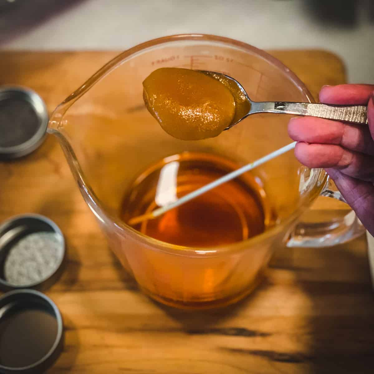 adding a spoonful of manuka honey to the oil mixture