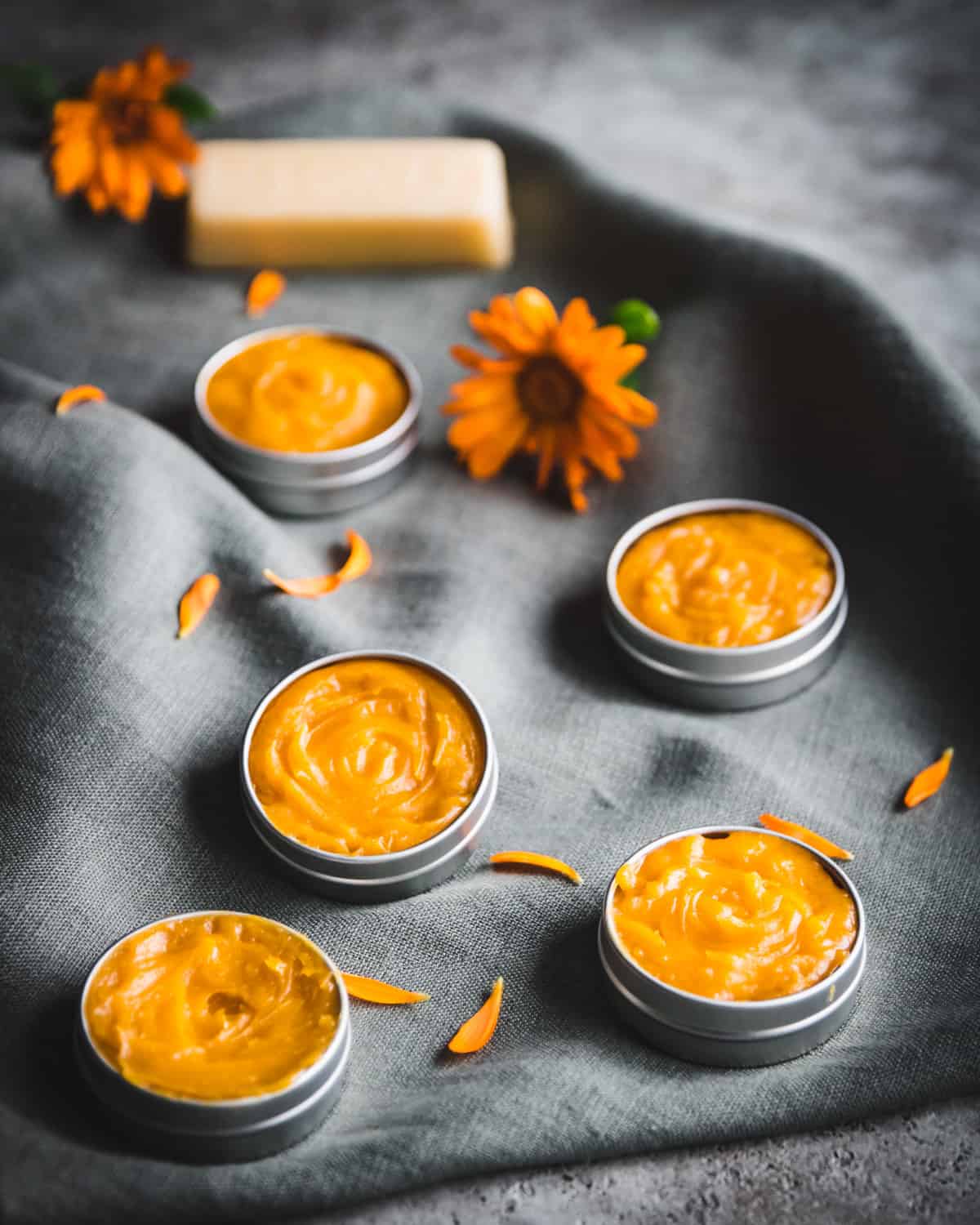 five tins of orange honey salve with calendula flowers