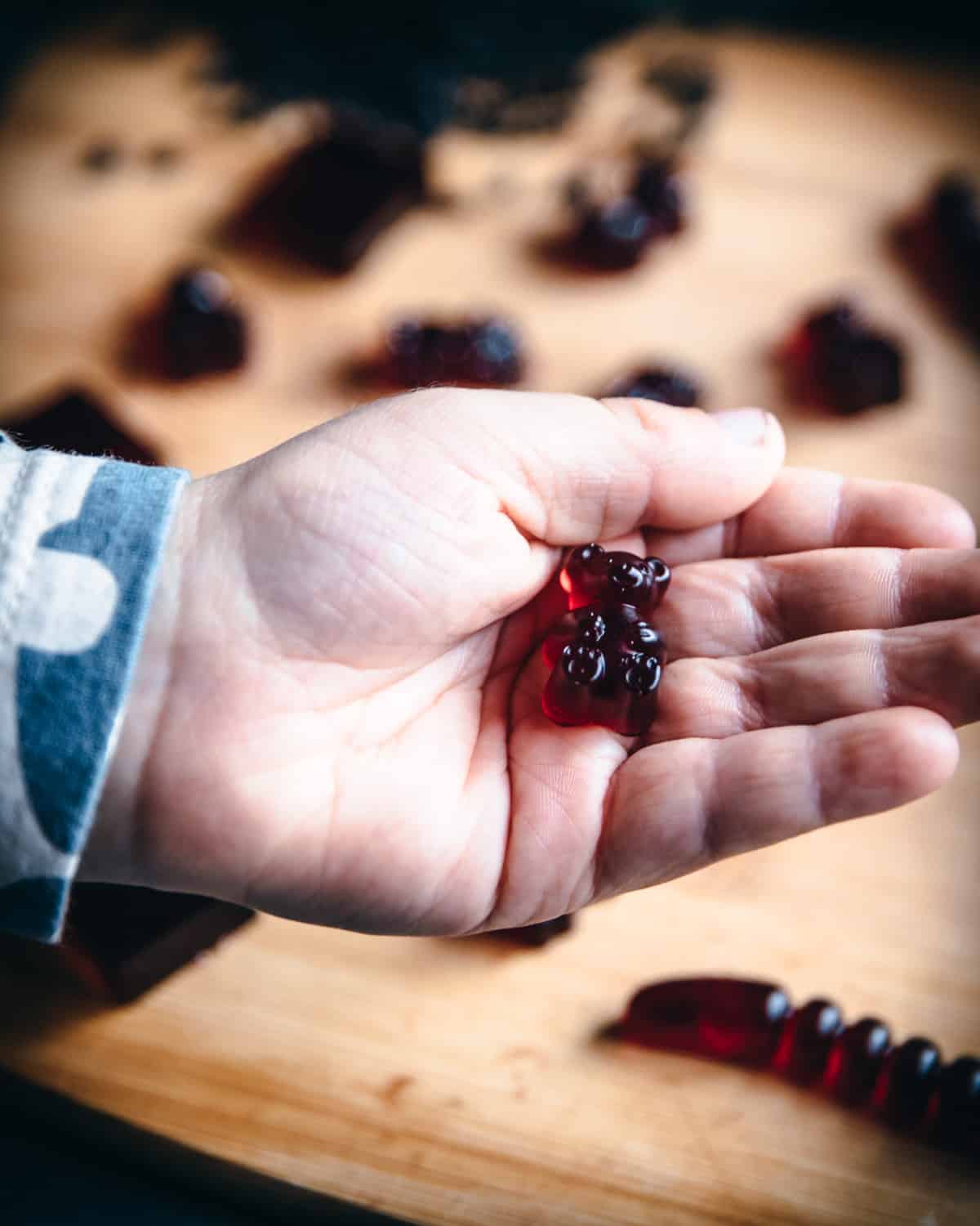 a childs had holding an elderberry gummy bear