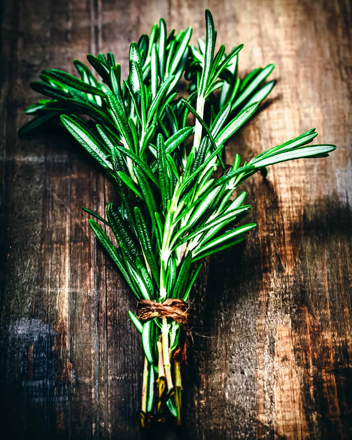 a bundle of rosemary on a wooden table