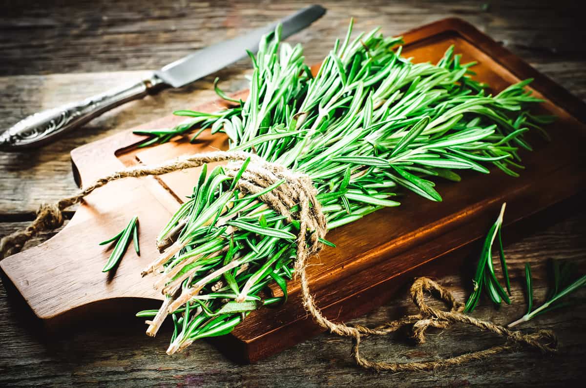 a bundle of rosemary on a cutting board