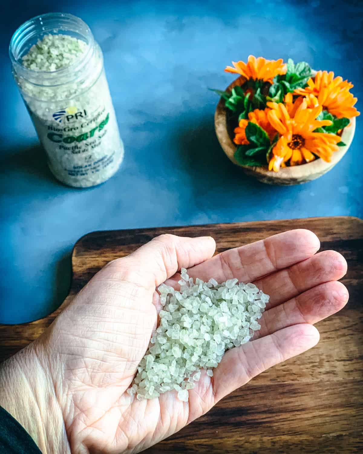 a hand holding coarse sea salt