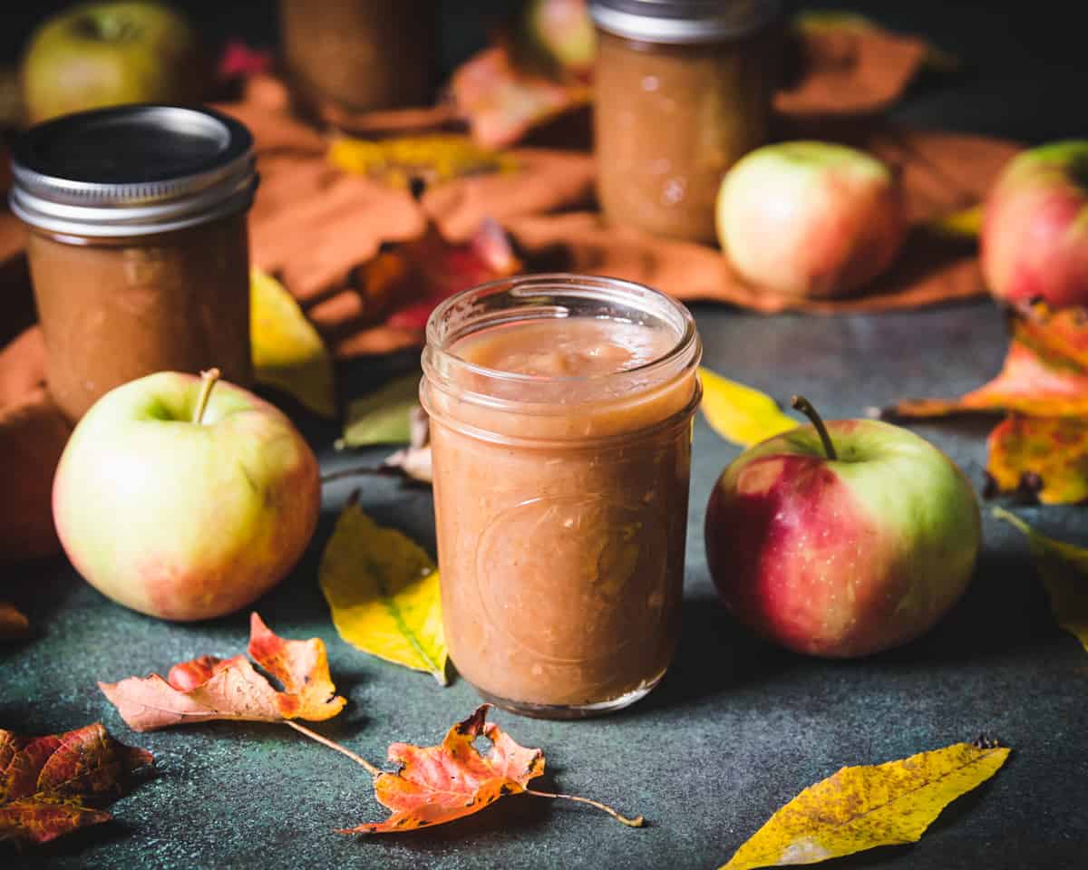 an opened jar of homemade spiced apple butter with maple syrup