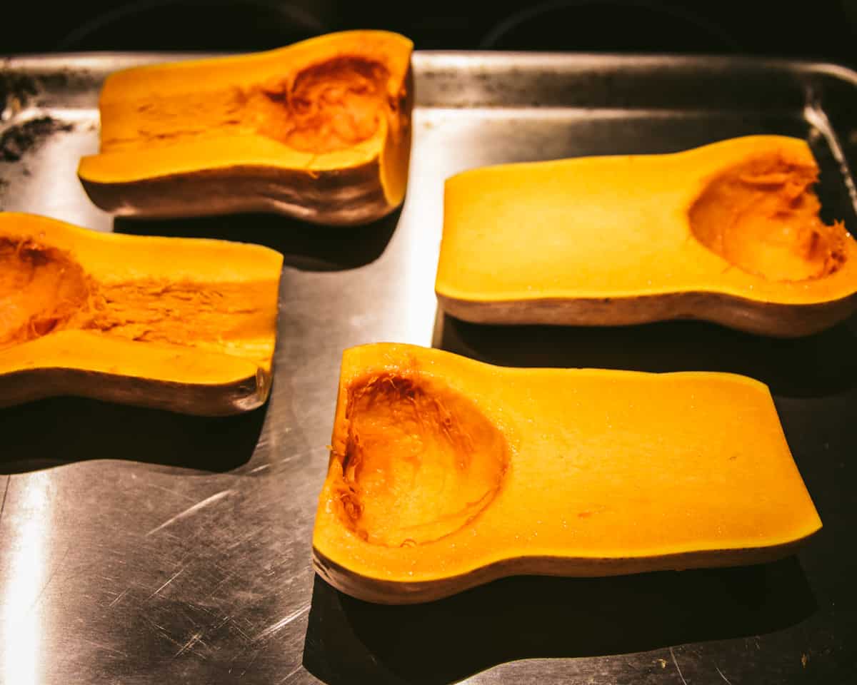 butternut squash on a baking sheet cut side up